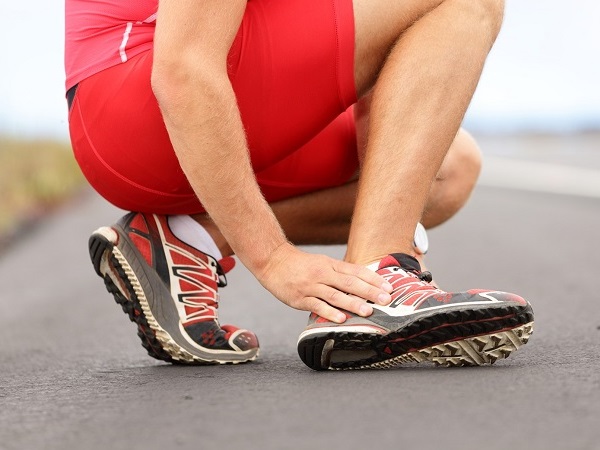 man touching his feet